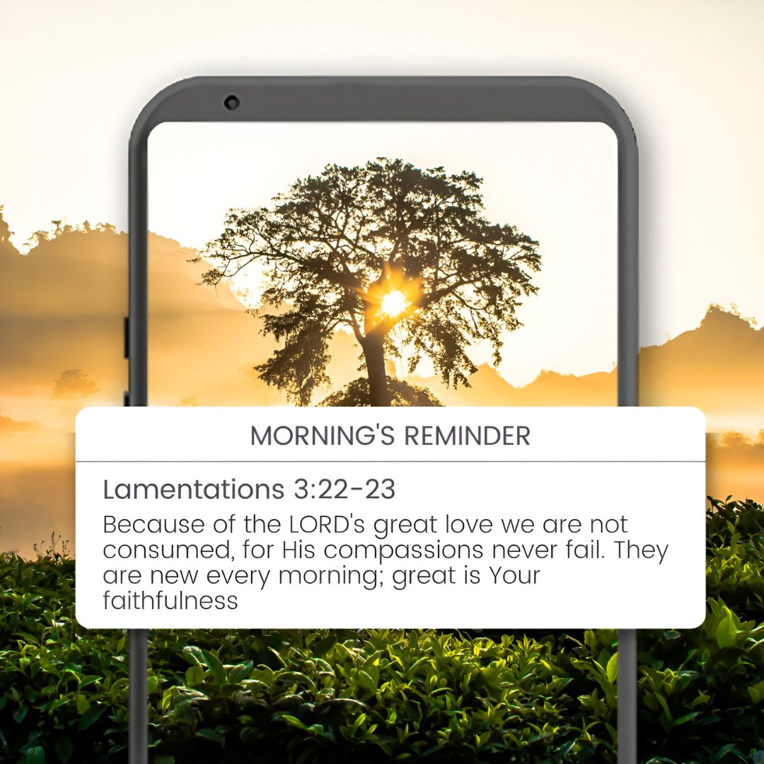 Morning's Reminder: A smartphone displays Lamentations 3:22-23 with a stunning sunrise behind a lone tree, representing blessing good morning Bible verses about God's enduring compassion and faithfulness.