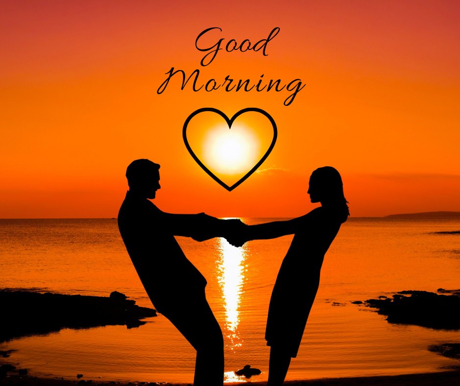 Good morning heart image capturing a romantic sunrise scene with a couple silhouetted against an orange sky, holding hands to form a heart shape around a glowing heart, under the script 'Good Morning.'