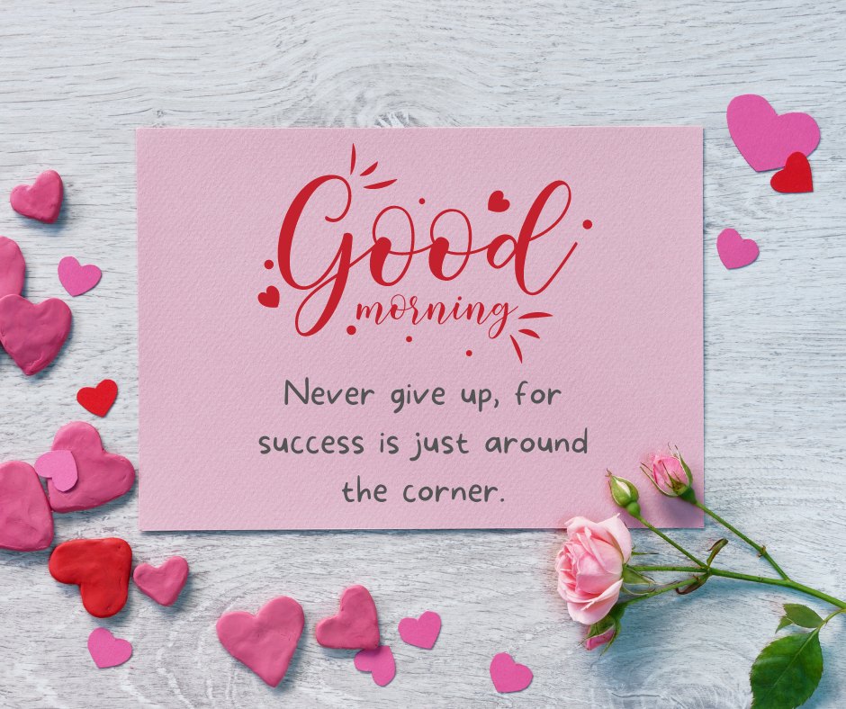 Good Morning Image with Rose Flowers featuring a pink card with motivational text surrounded by heart-shaped clay pieces and a delicate pink rose on a wooden texture.