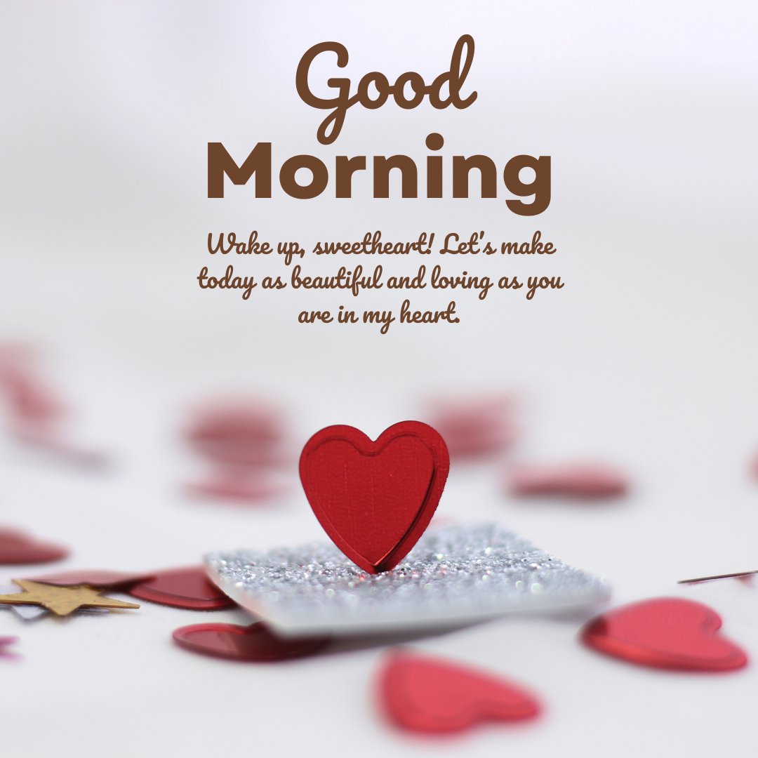 A heartfelt good morning message for her, featuring a red heart on a silver glitter background, with text that says 'Wake up, sweetheart! Let's make today as beautiful and loving as you are in my heart.'